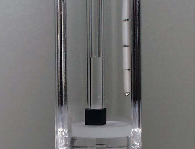 Elastomer cube specimen in TMA instrument for thermal expansion CLTE measurement.